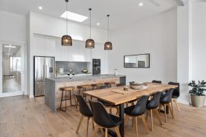 a large kitchen with a wooden table and chairs at Beachfront Bliss Luxury Views in Rye