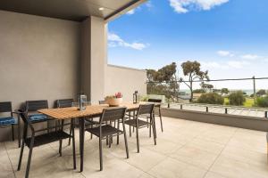 a dining room with a table and chairs on a balcony at Beachfront Bliss Luxury Views in Rye