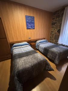 two beds in a hotel room with acknowled at Hostal San Juan Oyarbide Tolosa in Tolosa