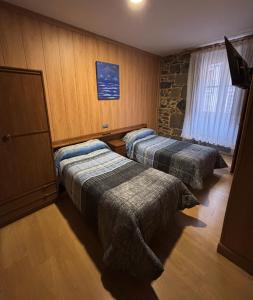 a hotel room with two beds and a window at Hostal San Juan Oyarbide Tolosa in Tolosa