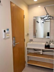 a bathroom with a sink and a mirror at EAIN-WORKplusSTAY in Bangkok