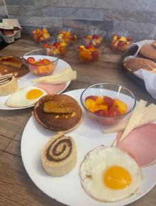 a table with plates of food and bowls of fruit at L'Océane Bed&Breakfast in Lacanau-Océan