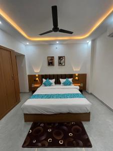 a bedroom with a large bed with a ceiling fan at Hotel Chunda Niwas in Dabok +3 photos