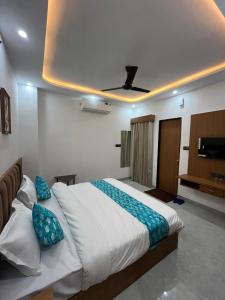 a bedroom with a large white bed with blue pillows at Hotel Chunda Niwas in Dabok