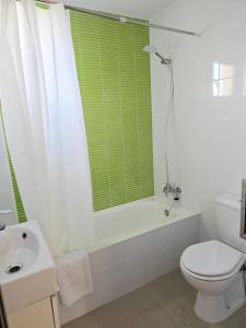 a white bathroom with a toilet and a sink at Atico playa de Miramar in Miramar