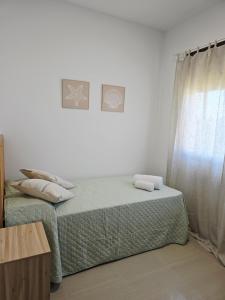 a bedroom with a bed with two pillows on it at Atico playa de Miramar in Miramar