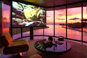 a living room with a tv and a glass table at Nya Uluwatu in Uluwatu