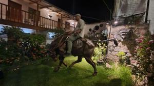 a man riding a horse in front of a house at Casona Mollepata in Mollepata