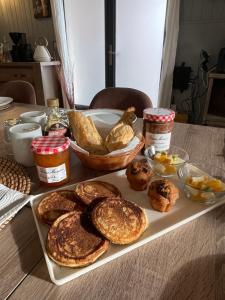 a table topped with a tray of pancakes and bread at L'Océane Bed&Breakfast in Lacanau-Océan