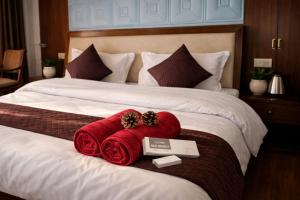a hotel room with two beds with red towels at Aura Montane luxury cottages in Manāli +13 photos