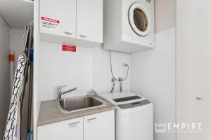 a small kitchen with a sink and a washing machine at Parklane Apartments in Fremantle +44 photos