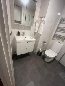 a white bathroom with a sink and a toilet at Nice flat in Barkarby in Järfälla
