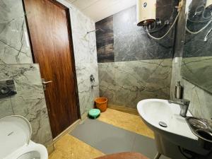 a bathroom with a toilet and a sink at JB Hotel and Resort in Lohaghāt