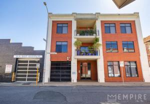 a red brick building on the corner of a street at Parklane Apartments in Fremantle