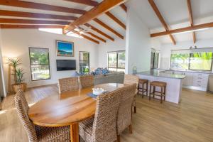 a dining room and kitchen with a wooden table and chairs at Amity Treetops - Prime Location - Sleeps 7 in Amity Point