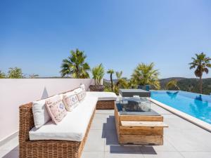a patio with a couch and a fireplace next to a swimming pool at Nice Villa in Budens with pool in Budens +112 photos