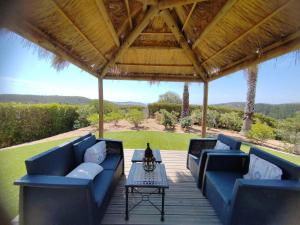 a patio with blue couches and a table and a roof at Nice Villa in Budens with pool in Budens