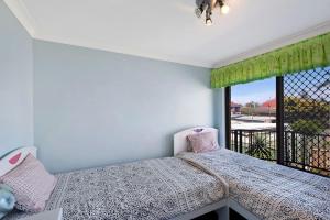 a bedroom with a bed and a balcony at Pelican Place in The Entrance