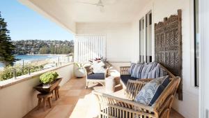 a porch with chairs and a couch on a balcony at The Palms in Palm Beach