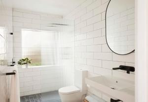 a white bathroom with a sink and a mirror at The Palms in Palm Beach +18 photos