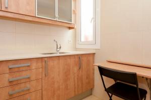 a kitchen with a sink and a black chair at Bbarcelona Apartments Plaza España Flats in Barcelona