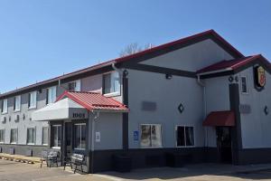a building with a hotel with chairs outside of it at Super 8 by Wyndham Jacksonville in Jacksonville