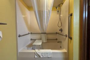 a small bathroom with a tub and a shower at Super 8 by Wyndham Jacksonville in Jacksonville +31 photos