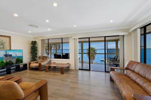 a living room with a couch and a table at Toukley Waterfront House in Toukley