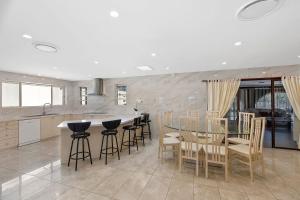 a kitchen with a glass table and chairs at Toukley Waterfront House in Toukley