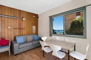 a living room with a couch and a table and chairs at The Sands Apartment 6 in The Entrance