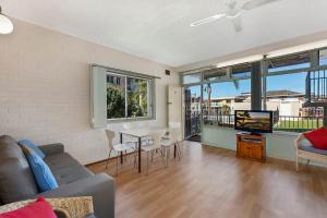 a living room with a couch and a table and a tv at The Sands Apartment 6 in The Entrance