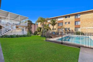 an apartment building with a swimming pool in a yard at The Sands Apartment 6 in The Entrance
