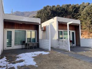 a house with a patio with a table in it at Over The Mountain in Gapyeong