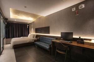 a hotel room with a bed and a desk with a computer at Zenith Hotel Bupyeong in Incheon
