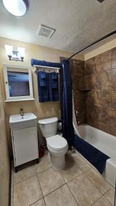 a bathroom with a toilet and a sink and a tub at Lighthouse Basement Guest Suite in Provo
