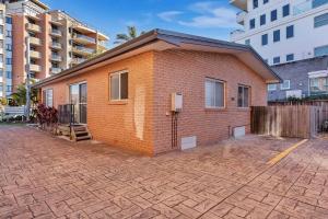 a small brick house with a brick driveway at Surfside Palms 14 in The Entrance