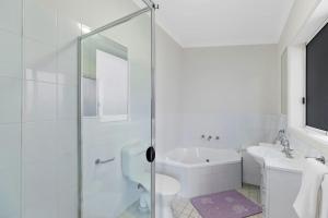 a bathroom with a shower and a toilet and a sink at Surfside Palms 14 in The Entrance