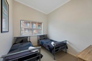 a small room with two beds and a window at Surfside Palms 14 in The Entrance