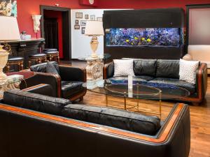a living room with couches and a fish tank at DORMERO Hotel Halle in Halle an der Saale