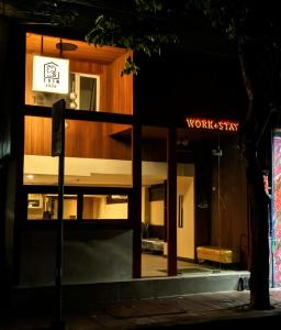 a night view of a building with a sign on it at EAIN-WORKplusSTAY in Bangkok