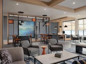 a lobby with chairs and tables and a living room at Hyatt House Schenectady / Mohawk Harbor in Schenectady