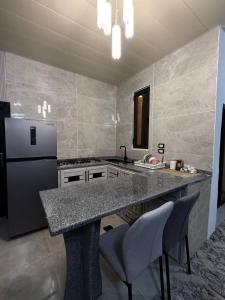 a kitchen with a counter and a refrigerator at Suf Hills Cabin in Jerash