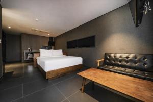 a hotel room with a bed and a couch at Zenith Hotel Bupyeong in Incheon