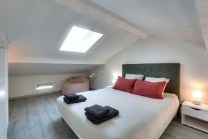 a bedroom with a bed with red pillows and a window at Appartement Santocha in Capbreton +14 photos