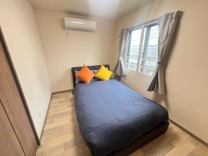 a small bed in a room with a window at ホロムア澄川 in Sapporo