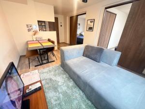 a living room with a blue couch and a table at ホロムア澄川 in Sapporo +124 photos