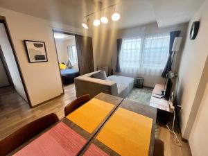a living room with a table and a room with a couch at ホロムア澄川 in Sapporo