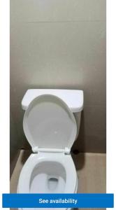 a bathroom with a white toilet in a stall at Eastdee AIRCON ROOM - RO1 in Biqui +11 photos