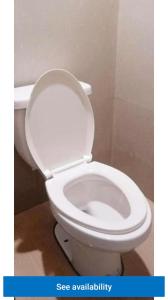 a white toilet with the lid up in a bathroom at Eastdee AIRCON ROOM - RO1 in Biqui