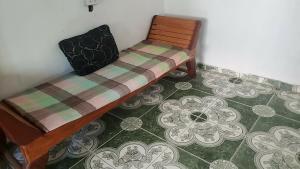 a wooden bench in a room with a tiled floor at Eastdee AIRCON ROOM - RO1 in Biqui